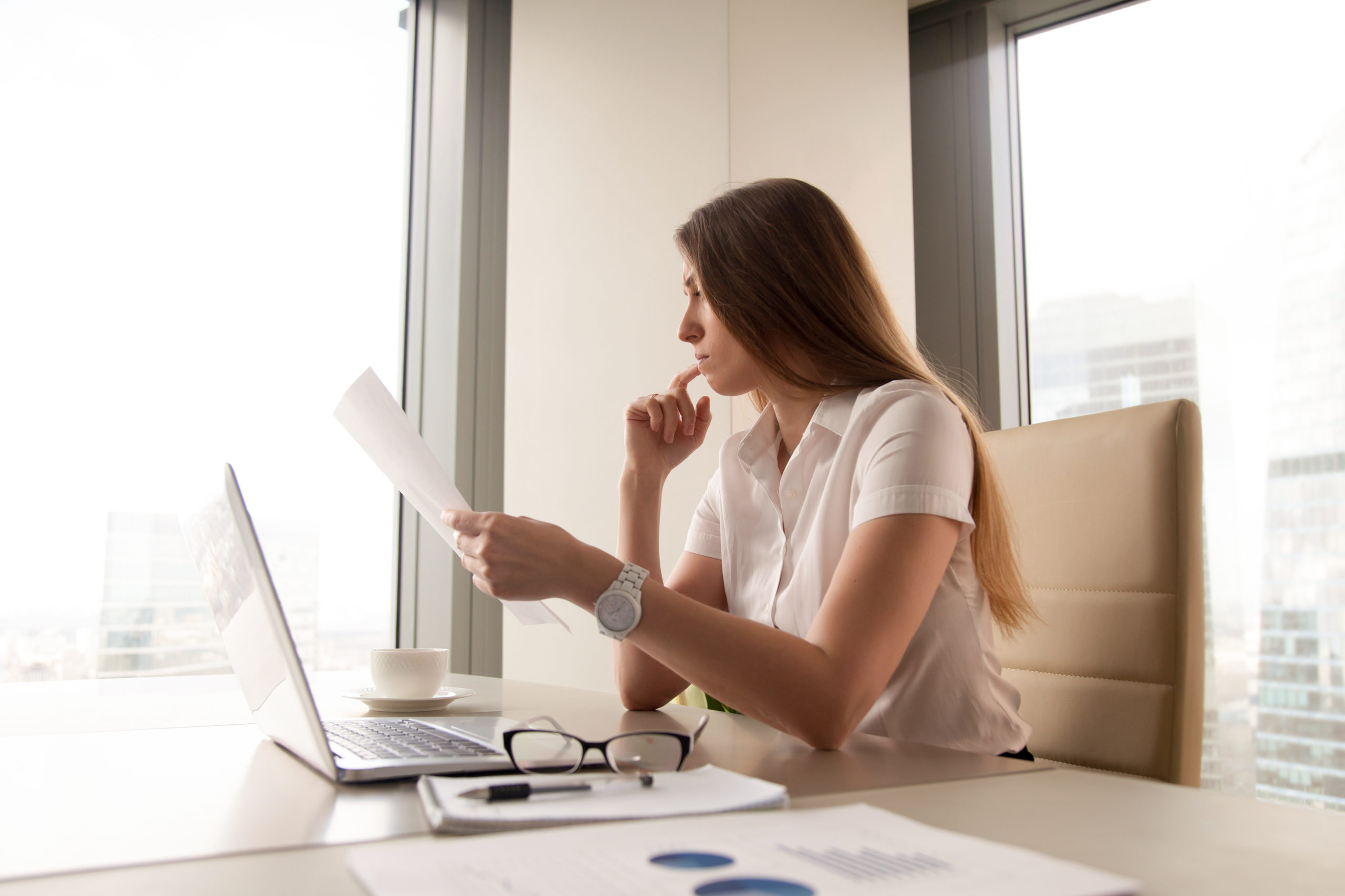 Pensive businesswoman reading document in office
